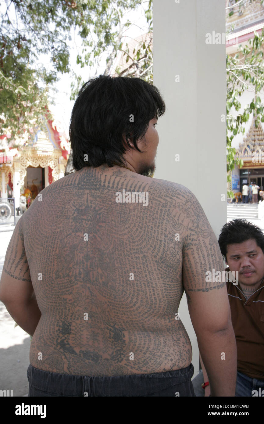 Un jeune homme, montre son tatouage au cours de Wai Kru Journée à Wat Phra Bang, un temple thaïlandais où les moines leur tatouage dévots. Banque D'Images