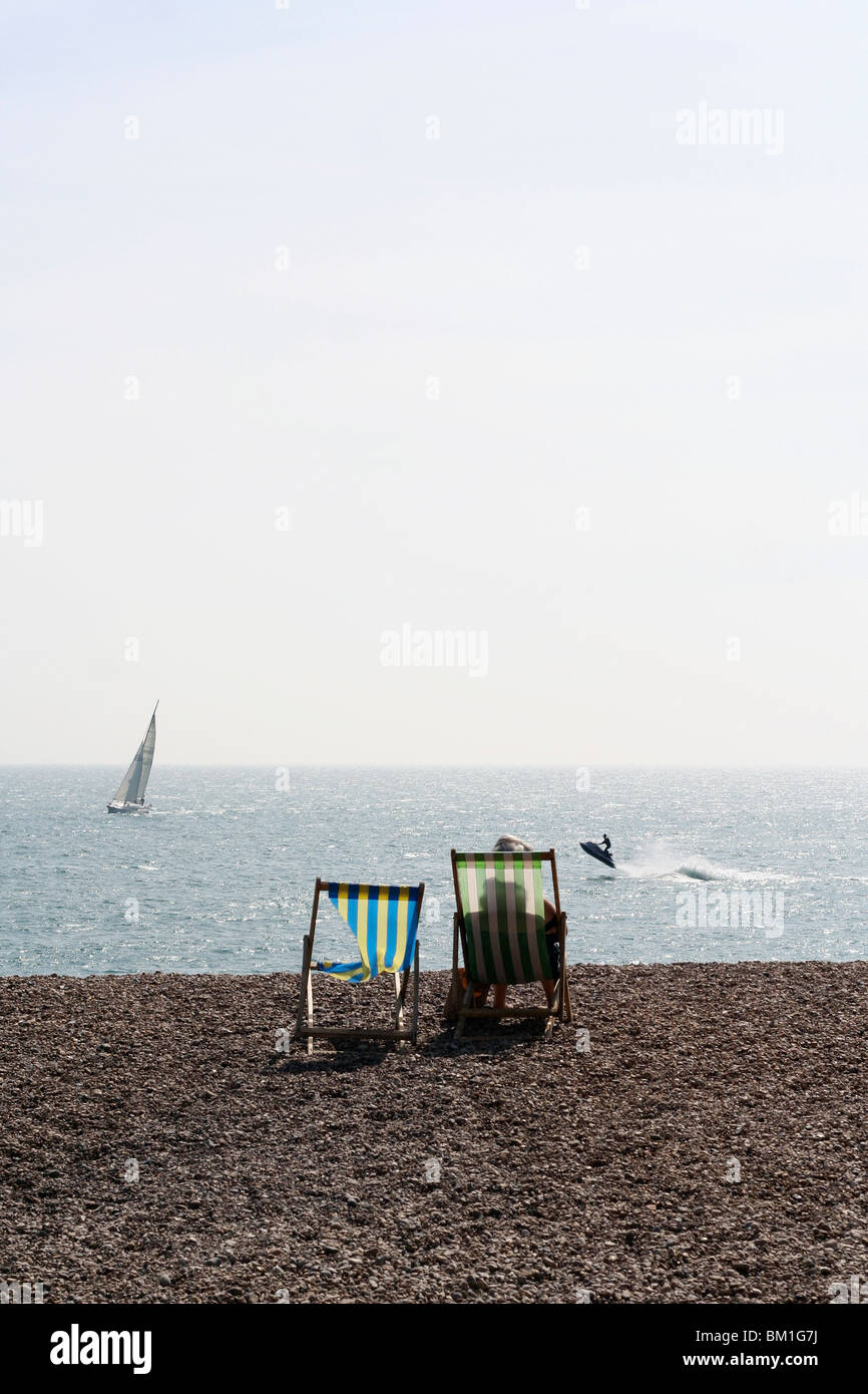 Vue sur mer ou sur la plage de Brighton juste à côté de la jetée, un portrait d'une petite vague et un bateau à voile au loin. Banque D'Images
