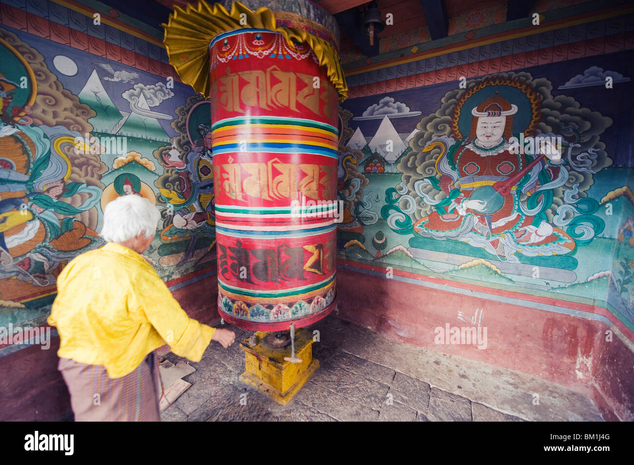 Une femme de prière spinning wheel, Chimi Lhakhang datant de 1499, le Temple du Lama Drukpa Kunley fou divin, Punakha, Bhoutan Banque D'Images