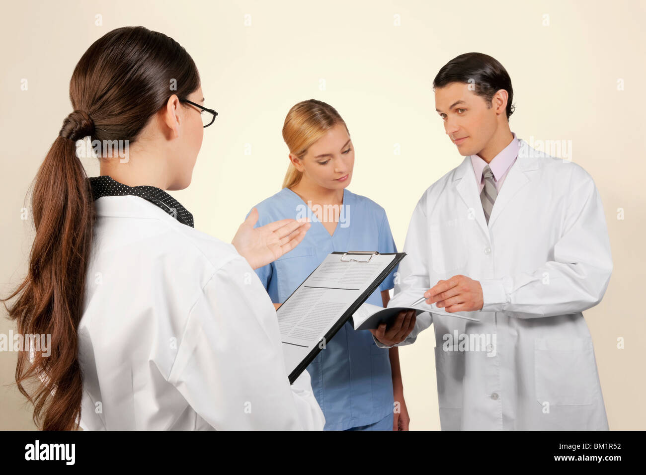 Les médecins et une infirmière de discuter au sujet de l'enregistrement médical Banque D'Images Les médecins et une infirmière de discuter au sujet de l'enregistrement médical Banque D'Images