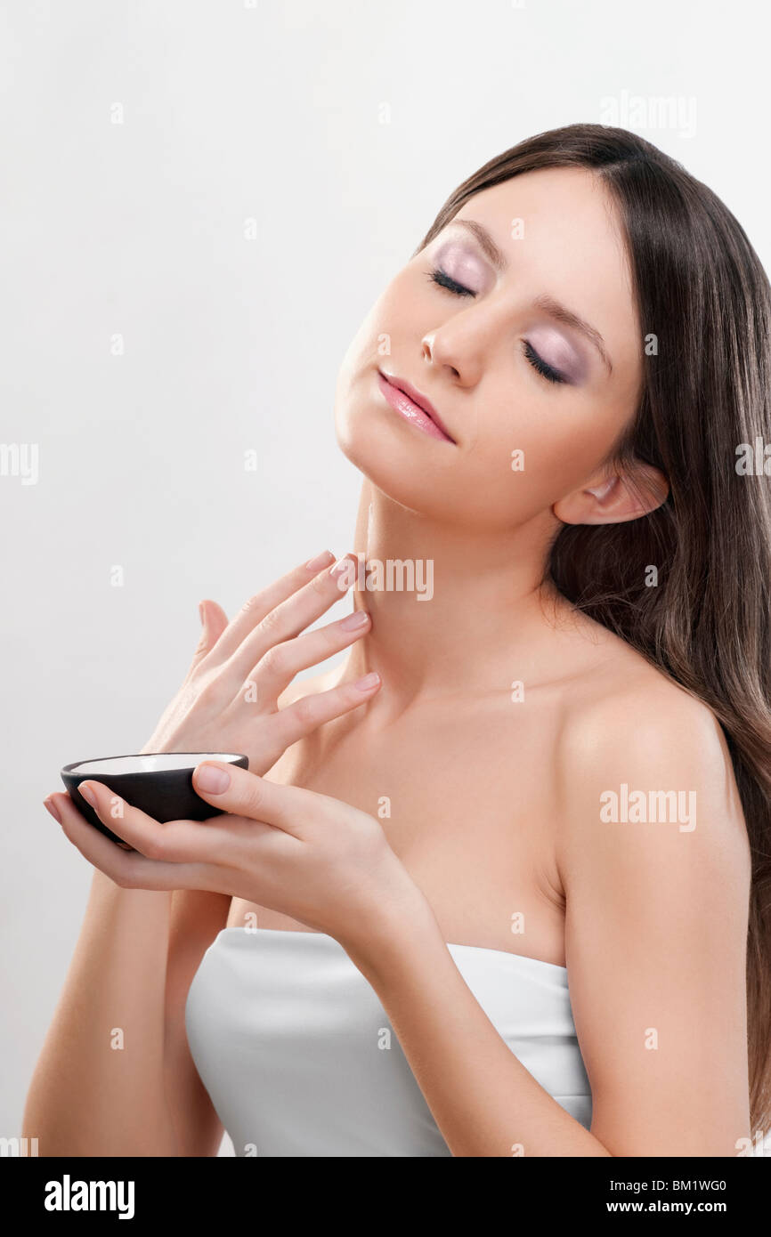 Woman applying moisturizer cream sur son cou Banque D'Images