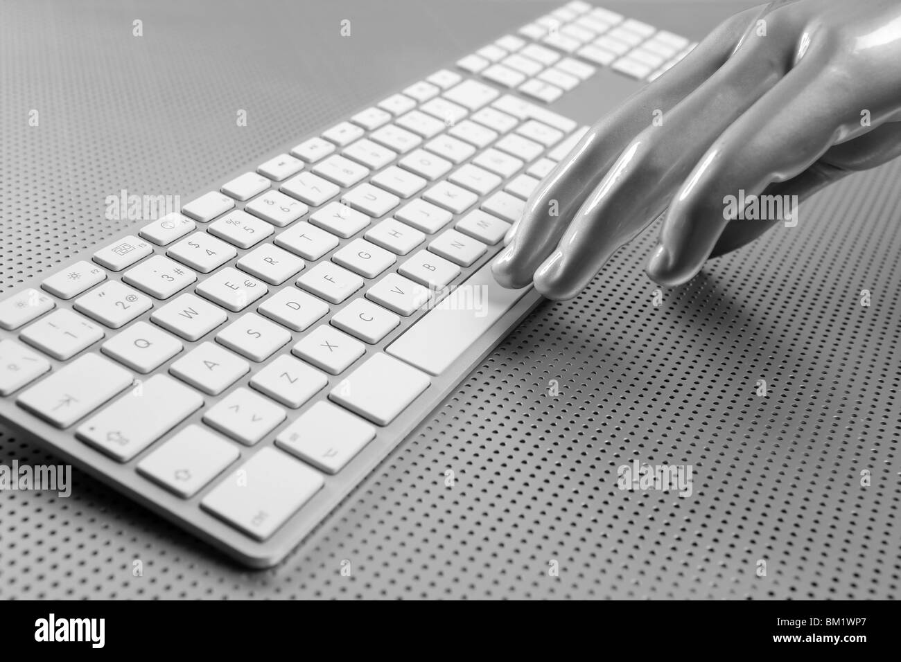 Main gris argent futuriste et clavier de l'ordinateur Banque D'Images