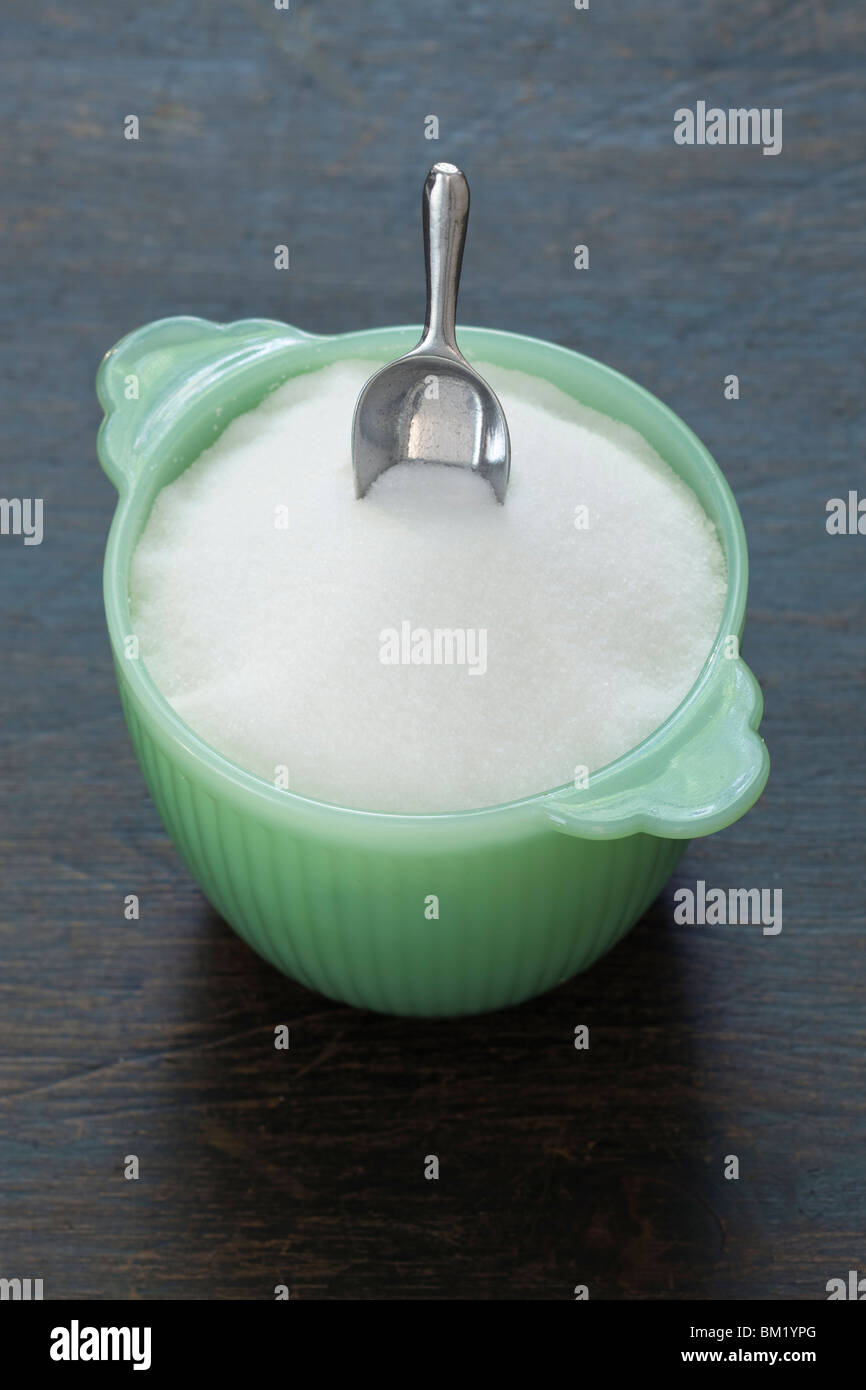 Bol de sucre en verre vert avec mini scoop Banque D'Images
