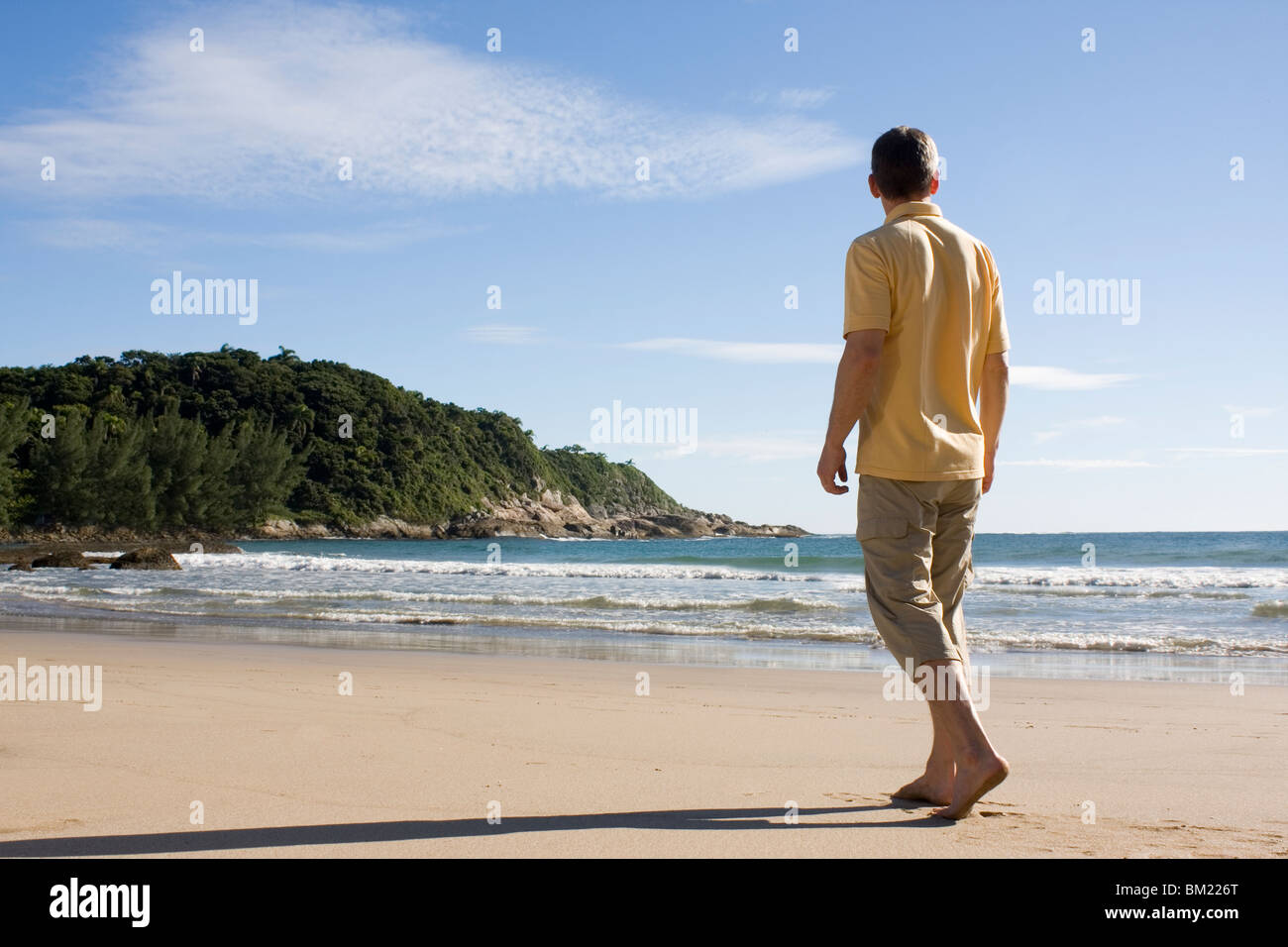 Homme mûr marchant pieds nus sur une plage tropicale au Brésil Banque D'Images