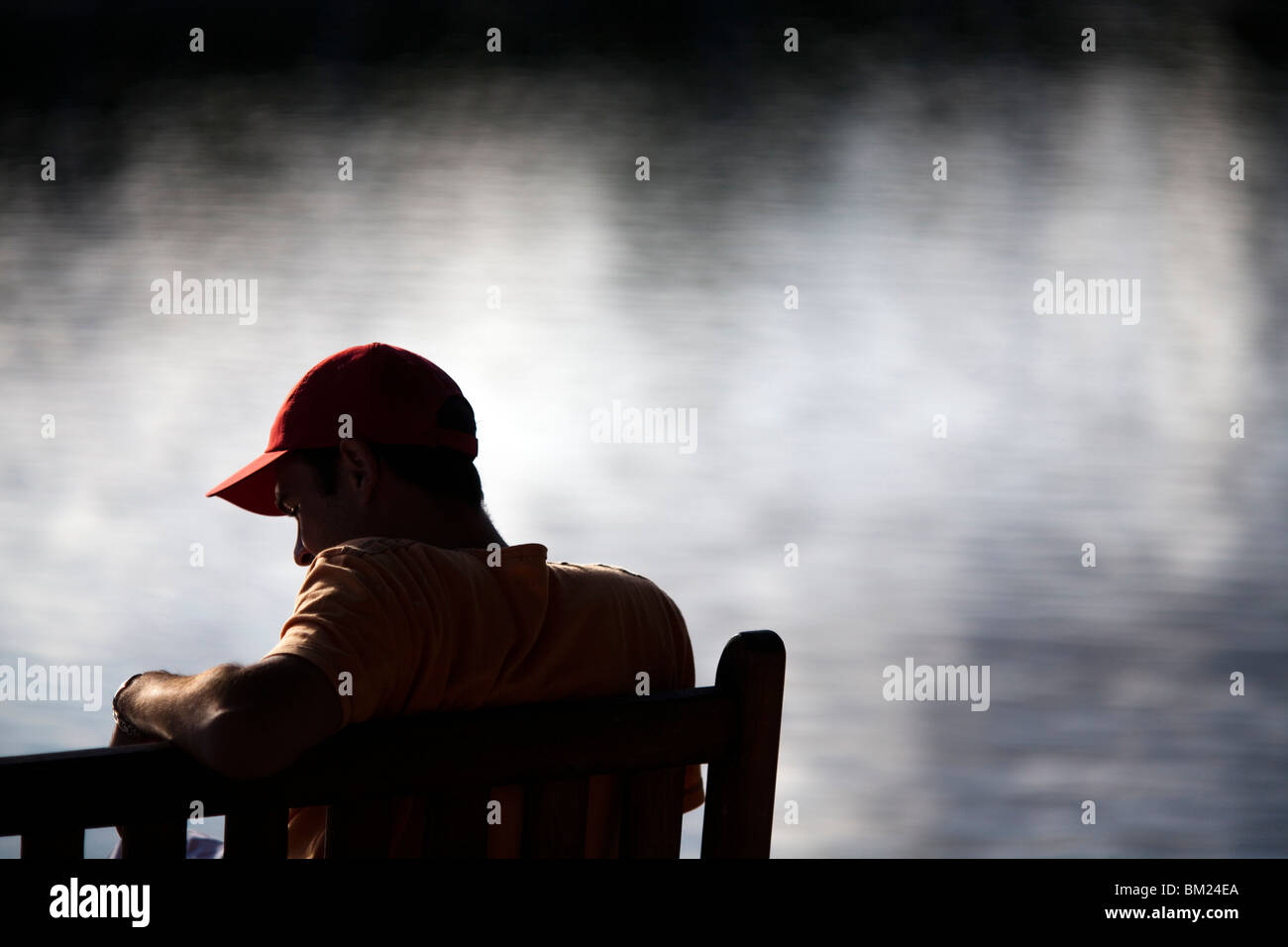 Jeune homme assis sur un banc au bord de la mer, l'île de Conleau, ville de Vannes, Departament de Morbihan, Bretagne, France Banque D'Images