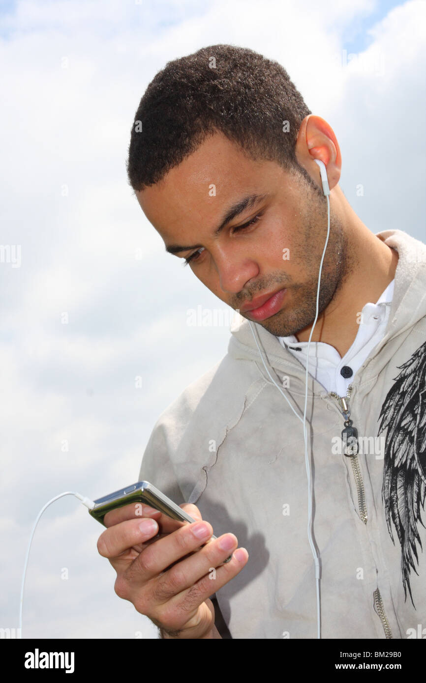 Footballeur professionnel Ben Fairclough à écouter de la musique sur un lecteur MP3 Ipod. Banque D'Images
