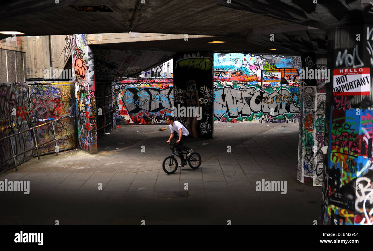 Cycliste à la graffiti zone utilisée par roulettes au South Bank à Londres UK Banque D'Images