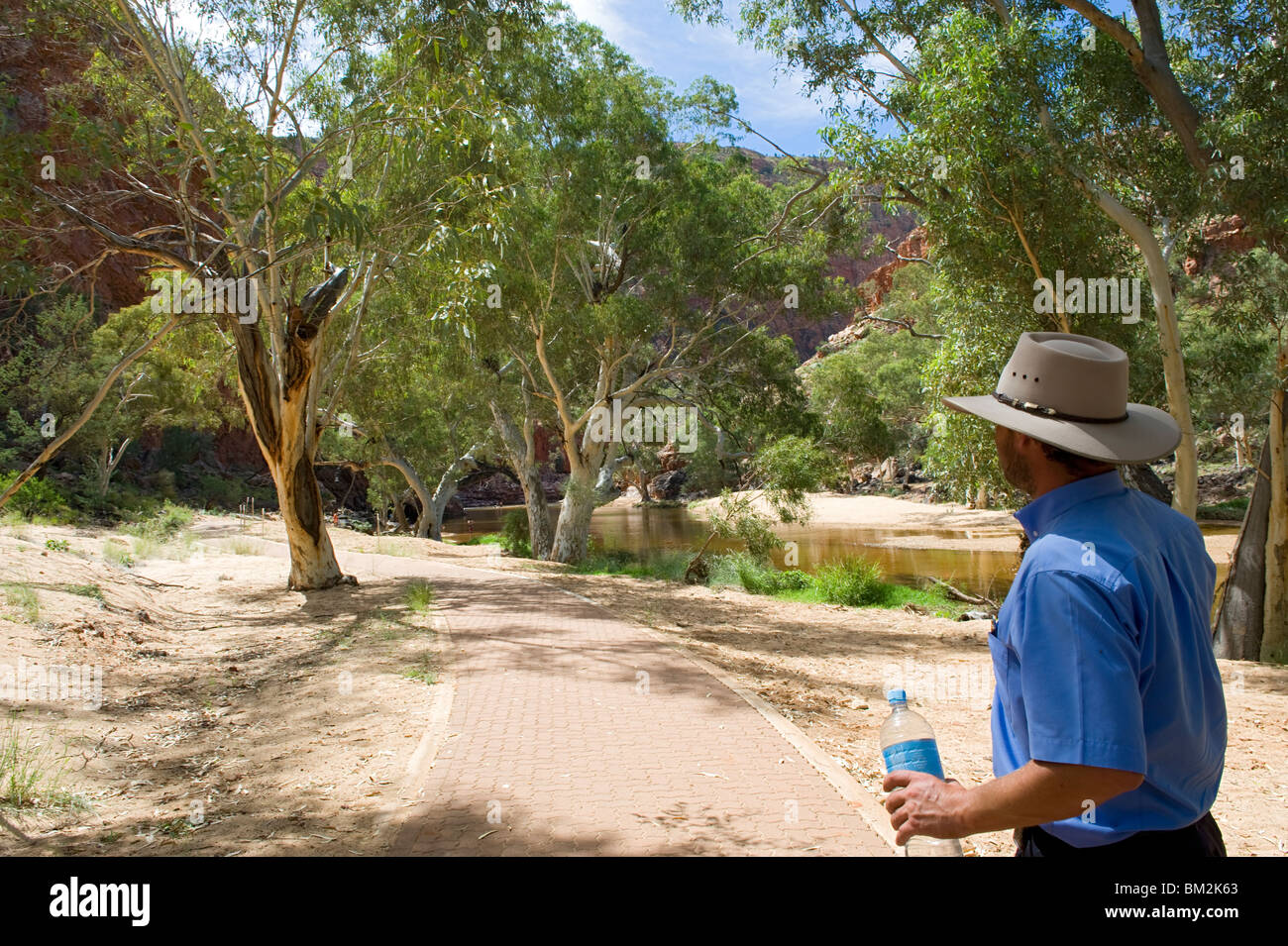 Un homme avec chapeau typique balade à Ormiston Gorge, dans l'Ouest MacDonnell, Territoire du Nord, Australie Banque D'Images