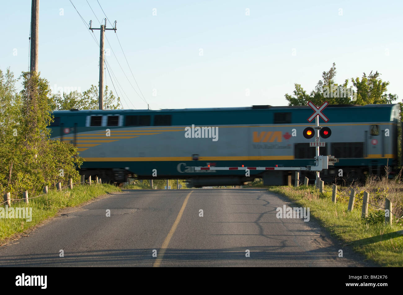 Un train de Via Rail se déplace dans un passage à niveau. Banque D'Images