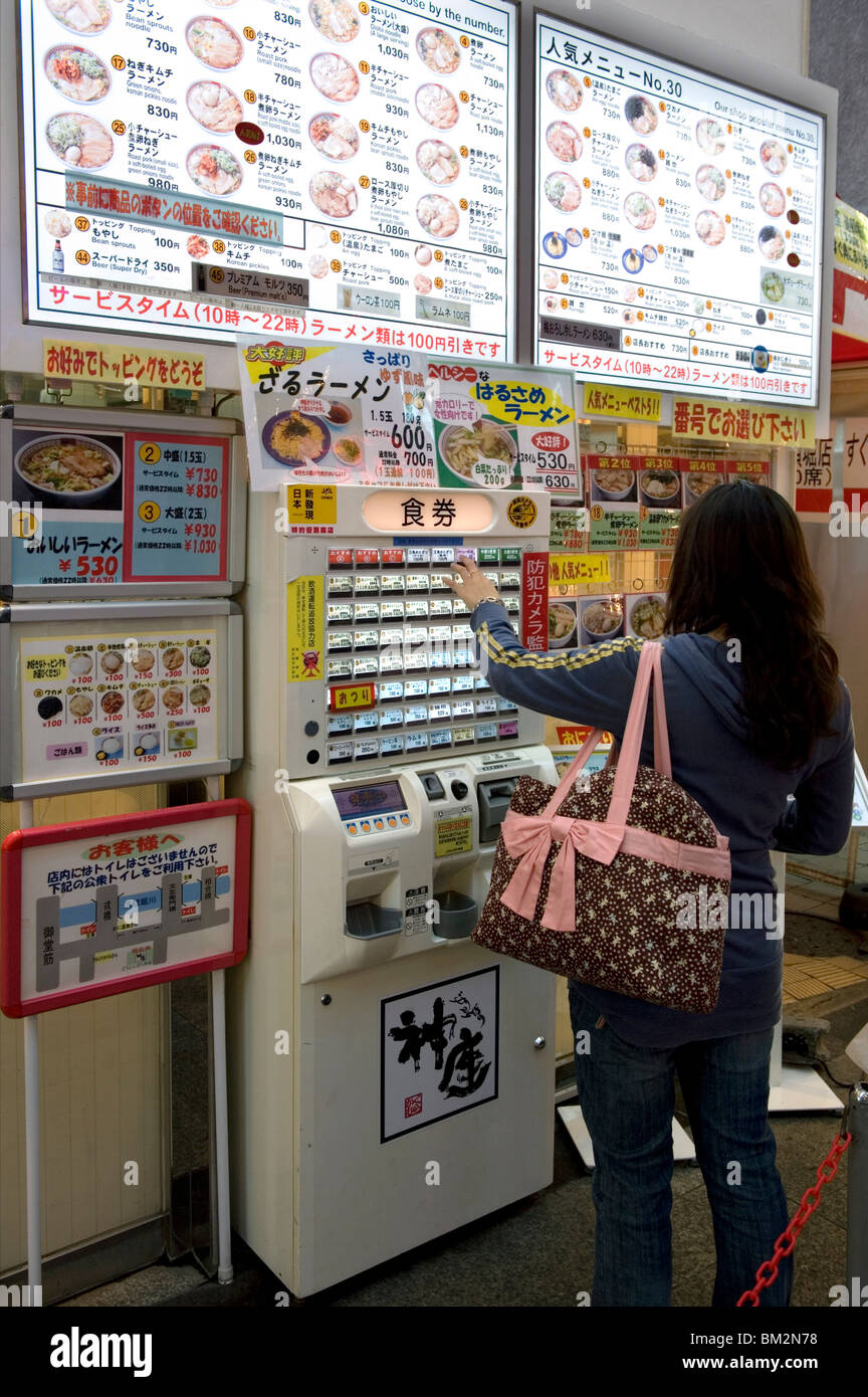 L'achat de tickets repas Femme à partir d'un distributeur automatique dans un restaurant de Dotonbori, Osaka, Japon Banque D'Images