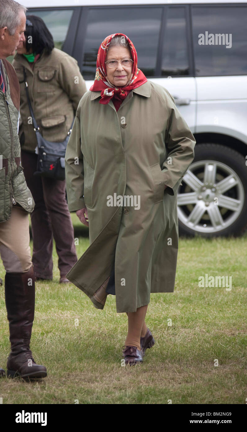 La Grande-Bretagne La reine Elizabeth II portant un imperméable et foulard rouge au Royal Windsor Horse Show Banque D'Images