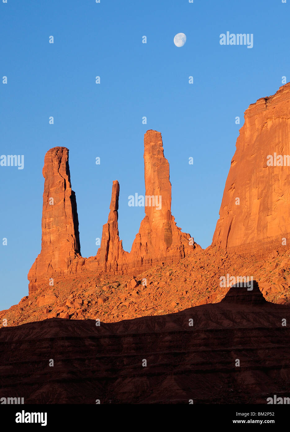 Monument Valley - Trois Soeurs au lever du soleil et lune avec réglage, l'Arizona et l'Utah, USA Banque D'Images