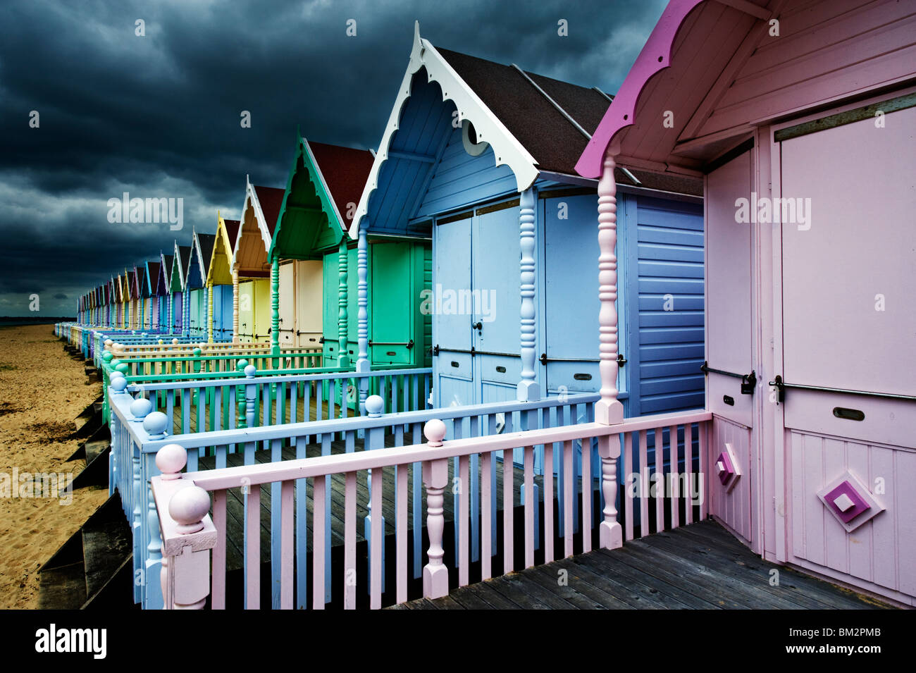 Cabines de plage en bois coloré au bord de la mer, sur l'île britannique Essex Mersea Banque D'Images