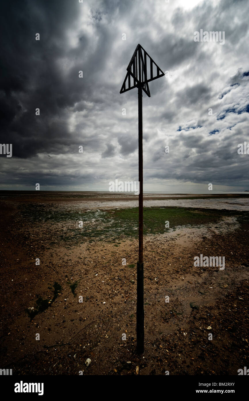 Marqueurs de navigation sur le sable à marée basse sur la plage à l'île britannique Essex Mersea Banque D'Images