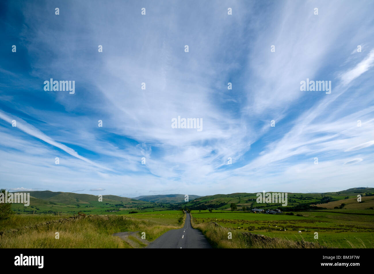 Cirrus nuages au-dessus de la route B6261, Crosby Ravensworth est tombé près de Tebay, Cumbria, England, UK Banque D'Images