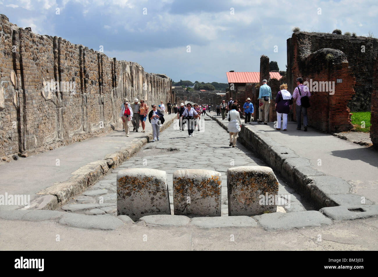 La Via dell'abbondanza avec trois blocs de pierre pour empêcher les véhicules circulant entre le Forum, Pompéi. Banque D'Images