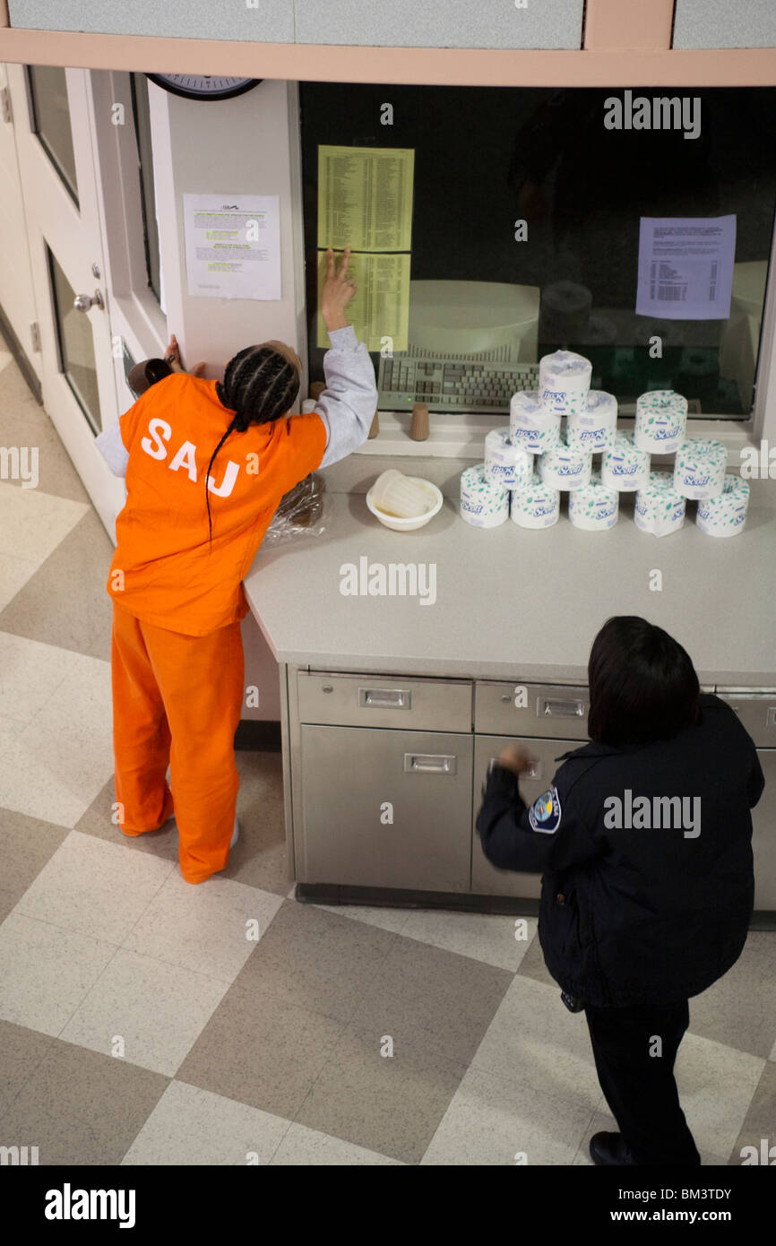 Un Afro-américain détenu dans l'Unité des femmes de la chambre jour Santa Ana, Californie, Ville Prison vérifie une liste de l'information posté. Banque D'Images