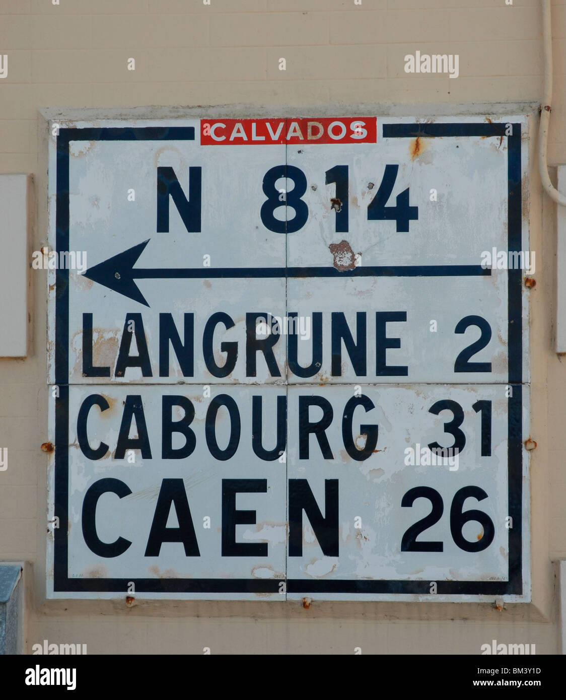 Route en direction de signe sur un mur à Bayeux, France Banque D'Images