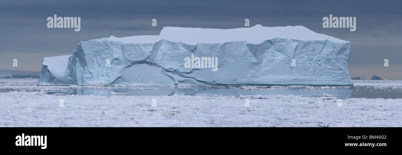 Les paysages panoramiques, l'avant du voyant du grand bleu iceberg flottant dans les eaux glacées de l'Antarctique sous fond de ciel orageux Banque D'Images