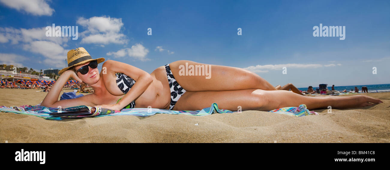 Femme allongée sur la plage dans une vue panoramique. Banque D'Images