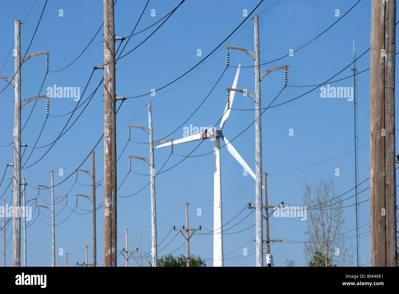 Éolienne pour les installations industrielles traditionnelles entre les lignes de quadrillage de l'énergie Banque D'Images