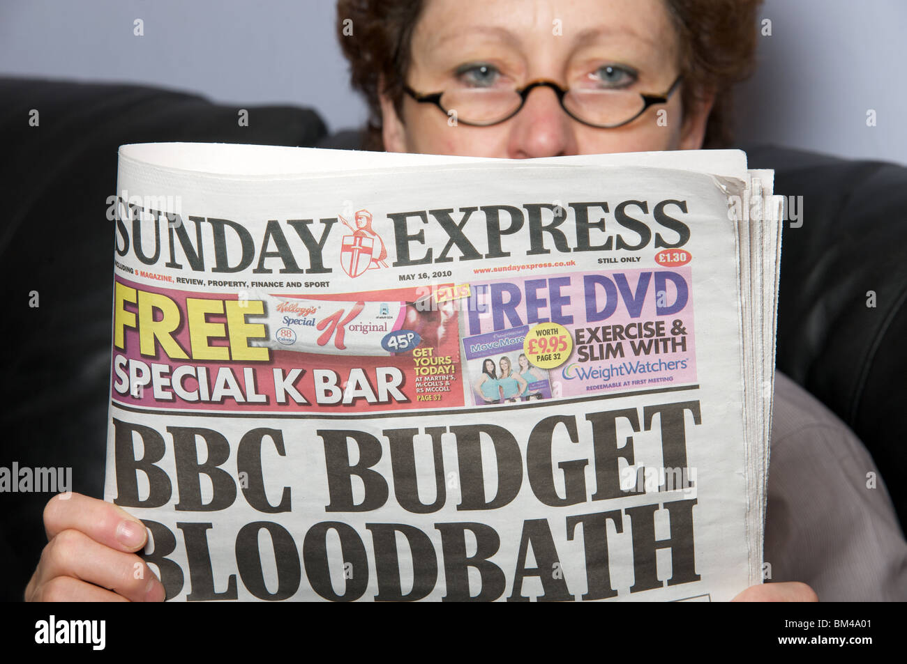 Femme lisant un exemplaire du journal Sunday Express Banque D'Images