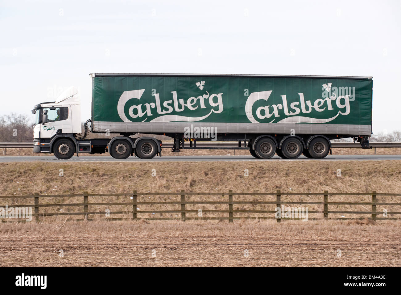 Un camion transportant des marchandises pour Carlsberg, voyageant le long d'une autoroute. Banque D'Images