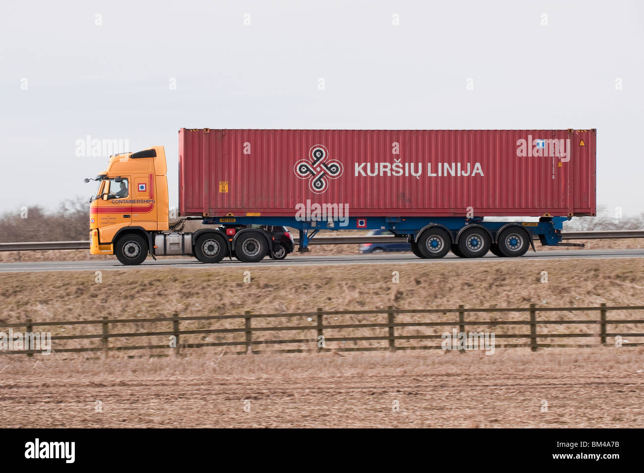 Un camion transportant un conteneur pour Kursiu Linija, voyageant le long d'une autoroute. Banque D'Images