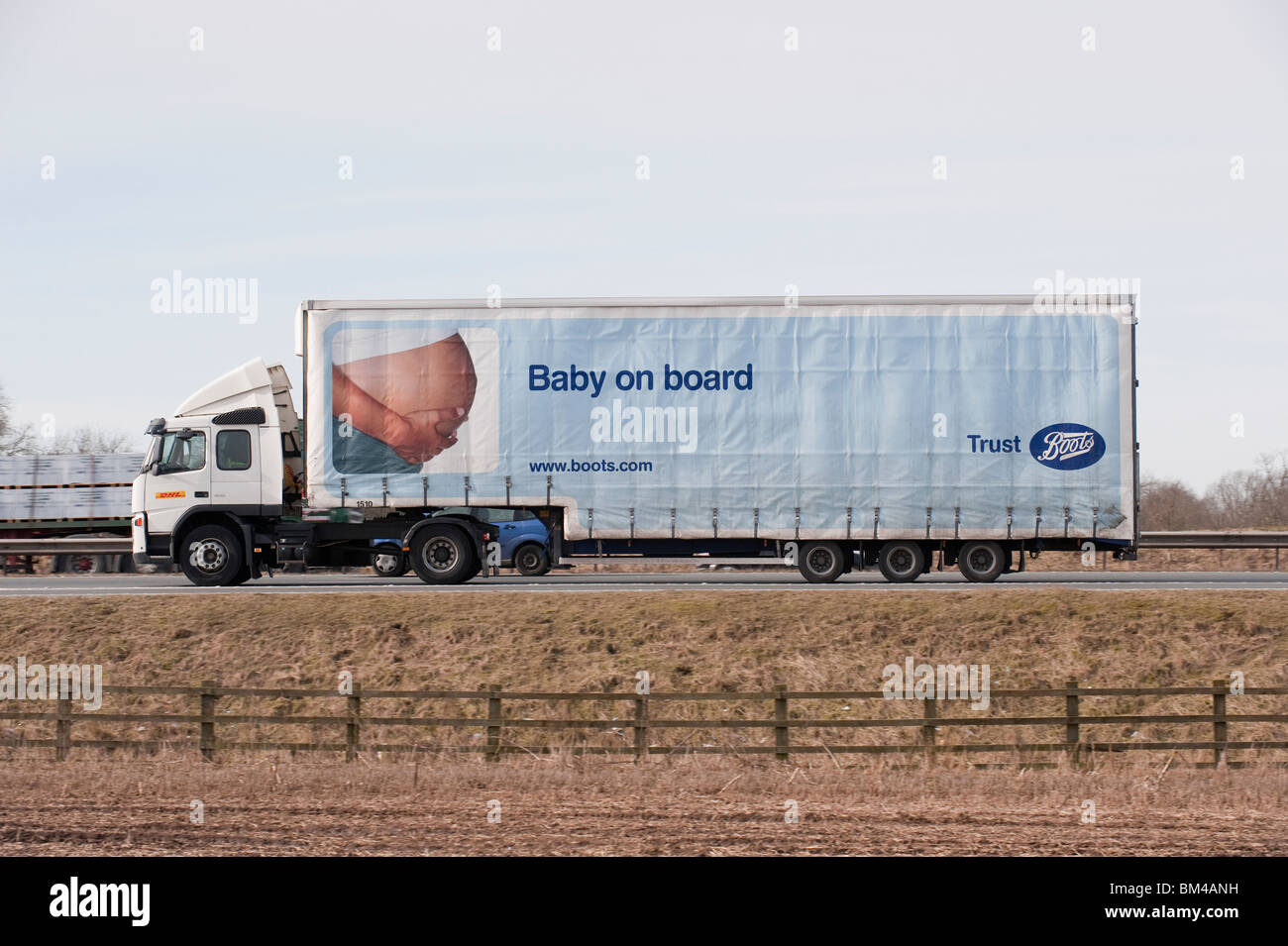 Un camion transportant des marchandises pour les bottes, voyageant le long d'une autoroute. Banque D'Images