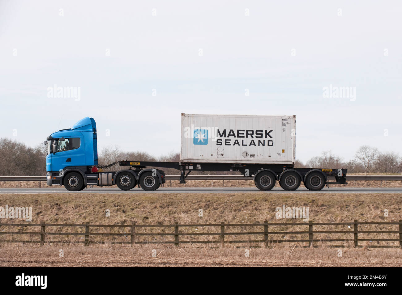 Un camion transportant un conteneur d'expédition pour le groupe Maersk, qui se déplacent le long d'une autoroute. Banque D'Images