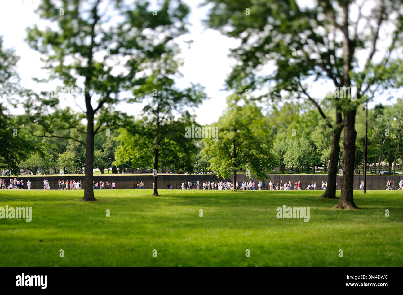 Monument commémoratif de la guerre du Vietnam Tilt-Shift Washington DC // WASHINGTON DC — Une photographie à bascule capture le monument commémoratif de la guerre du Vietnam, avec son emblématique mur noir et ses visiteurs. La technique photographique crée un effet miniature, soulignant la présence du mémorial dans le vaste paysage verdoyant de Washington D.C. Banque D'Images