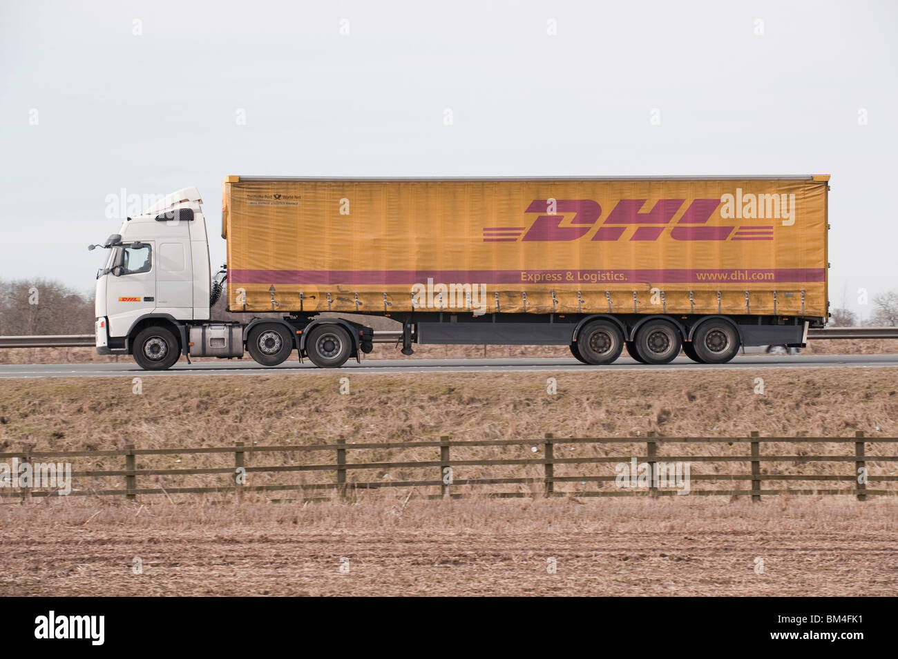 Un camion transportant des marchandises pour DHL, voyageant le long d'une autoroute. Banque D'Images
