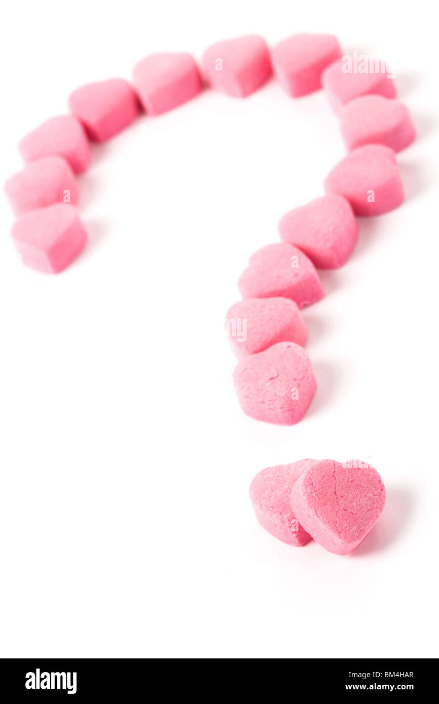 Bonbons en forme de coeur rose et point d'interrogation, l'amour casse-tête  Photo Stock - Alamy