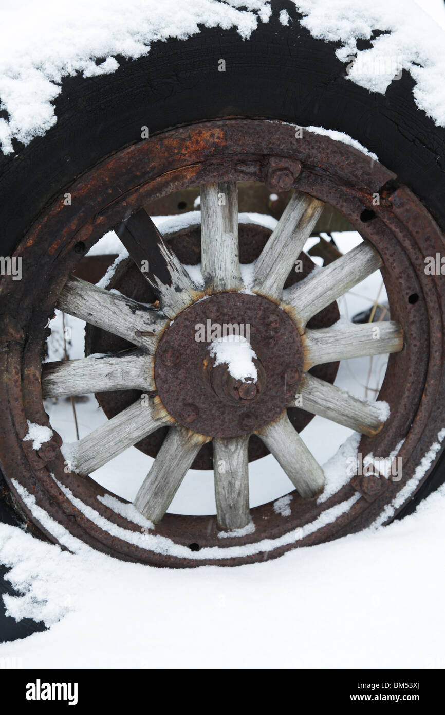 La neige recouvre un tracteur abandonné de moyeu de roue de chariot en bois d'un ancien véhicule sur une ferme en Finlande Banque D'Images