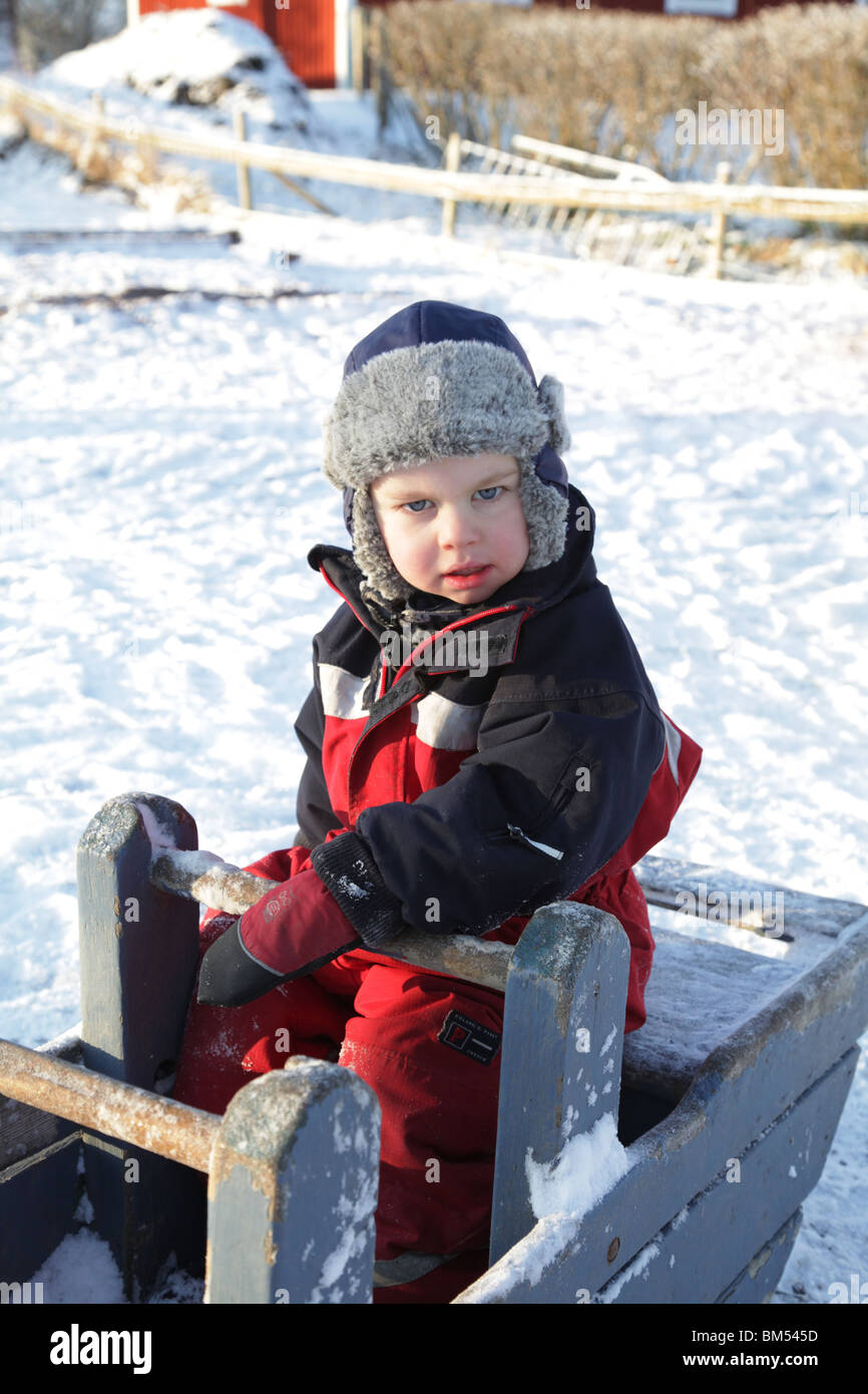 LES TOUT-PETITS JOUENT DANS LA NEIGE PROFONDE DE L'HIVER EN FINLANDE : un enfant de deux ans joue à la balançoire See-Saw Sea Saw Deep Snow Park Playground modèle libéré Banque D'Images