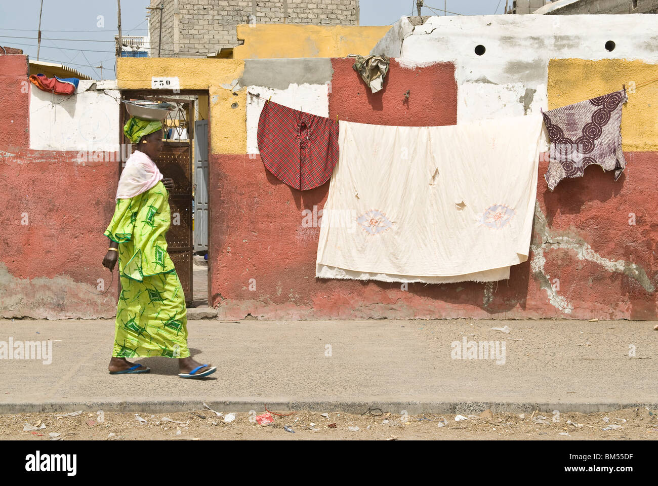 Vieille Femme avec des vêtements traditionnels en marchant dans la rue, Saint-Louis, Sénégal, Afrique. Banque D'Images