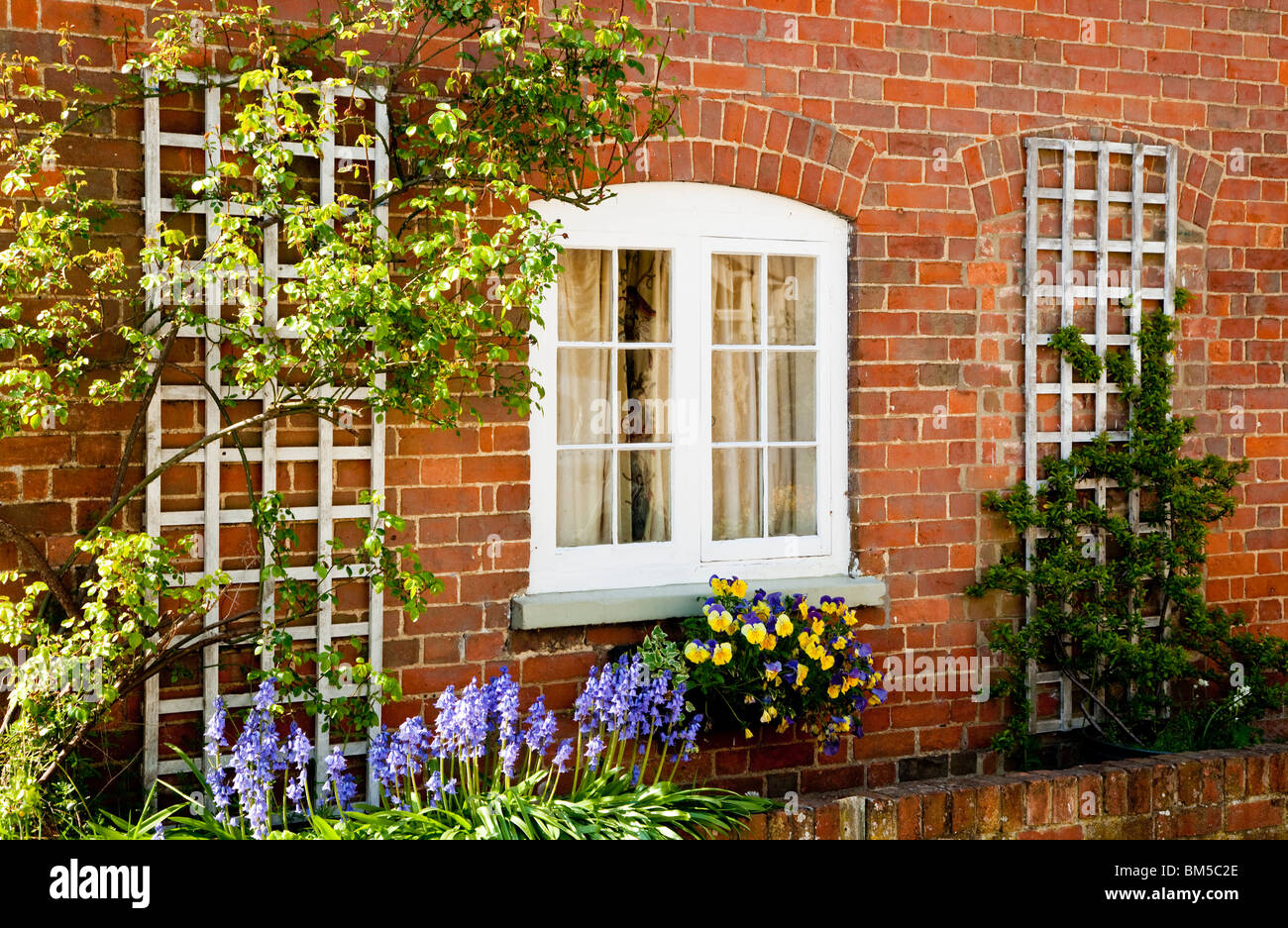 Une jolie fenêtre avec des fleurs dans une rangée de cottages en grande Somerford, Wiltshire, England, UK Banque D'Images