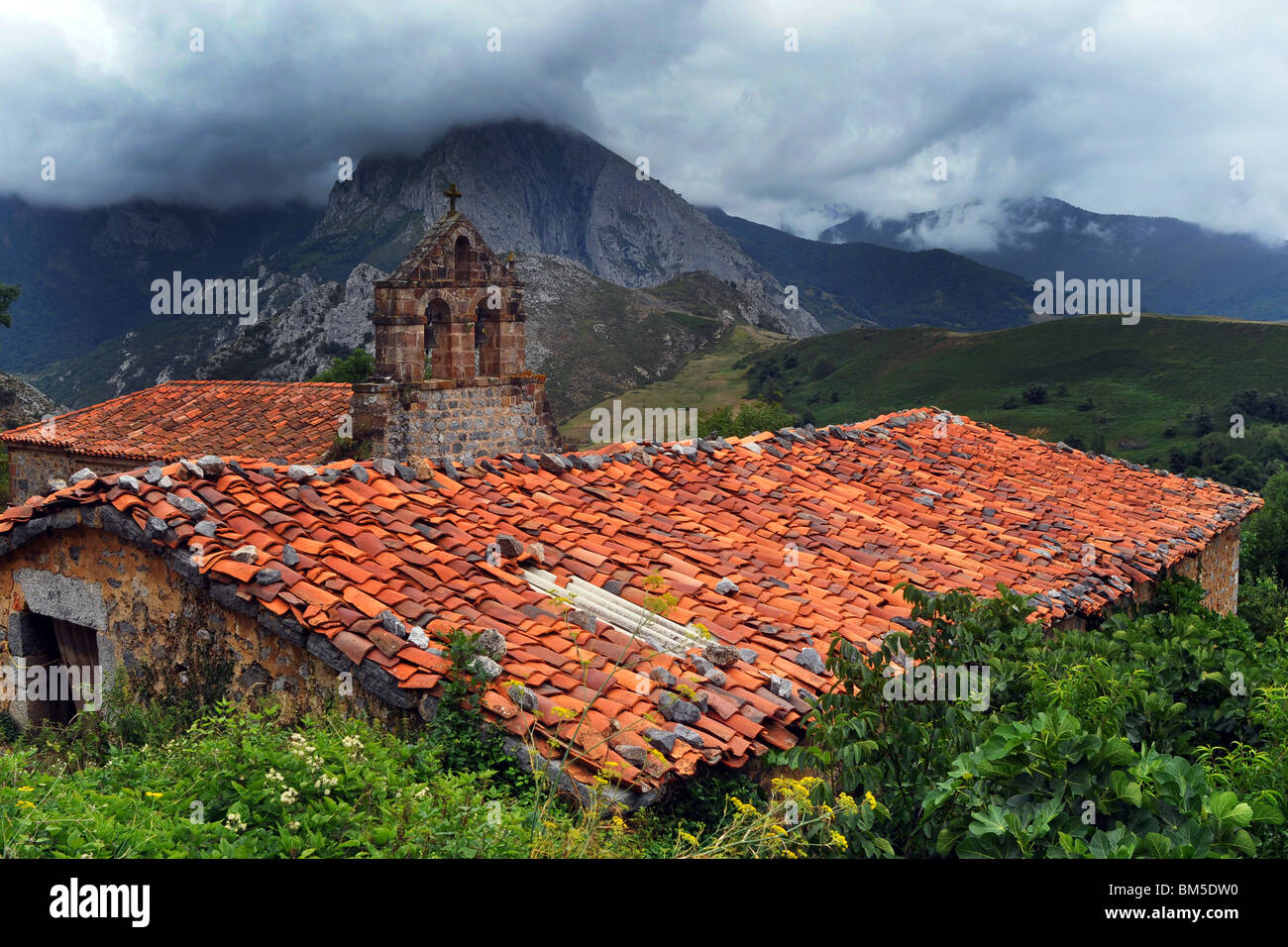 Un toit en tuiles rouges se détache sur les spectaculaires montagnes Picos de Europa d'Asturies, dans le Nord de l'Espagne Banque D'Images