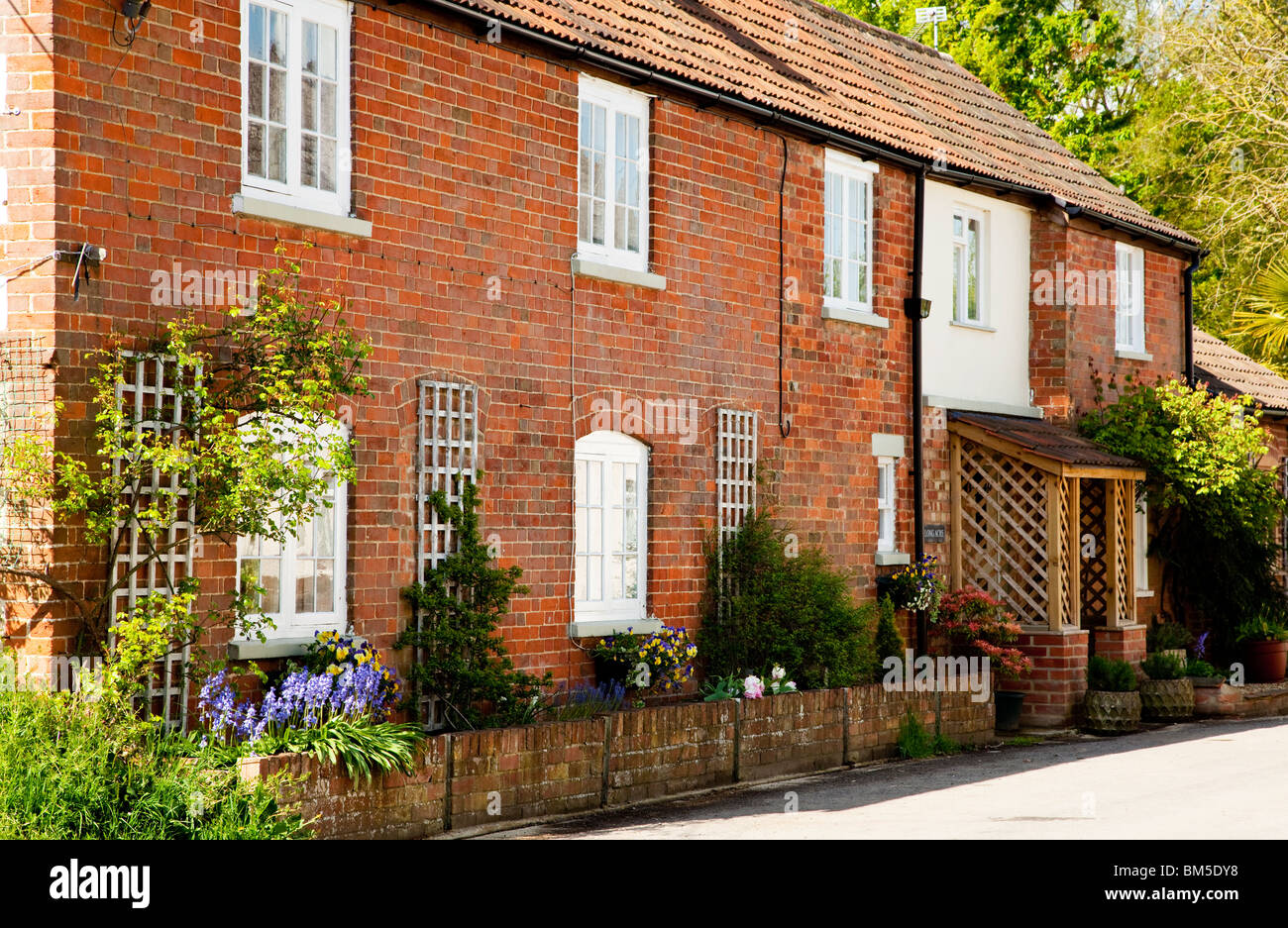 Un cottage en brique rouge dans le Wiltshire village de Grand Somerford, England, UK Banque D'Images