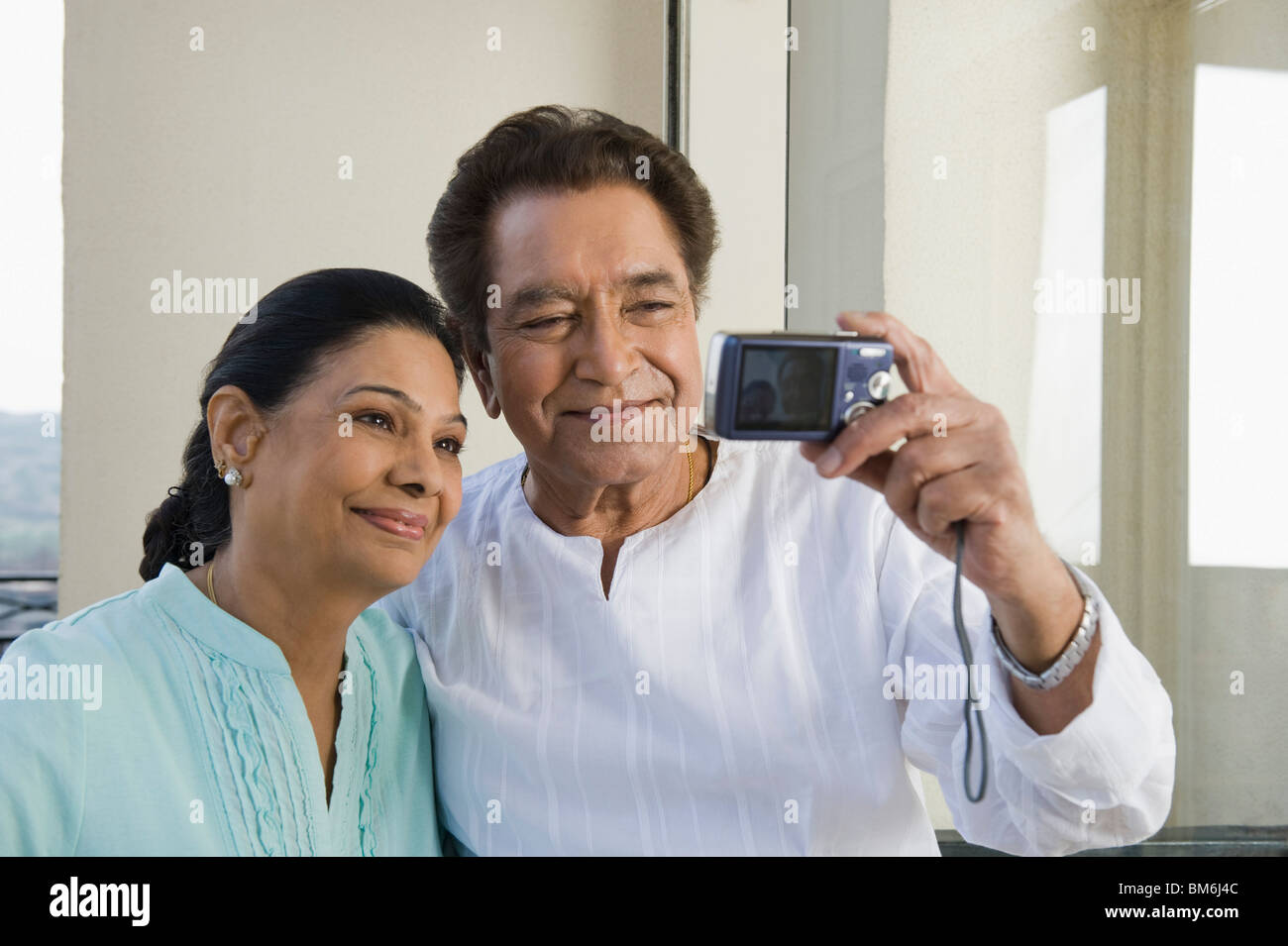 Couple de prendre une photo d'eux-mêmes avec un appareil photo numérique Banque D'Images
