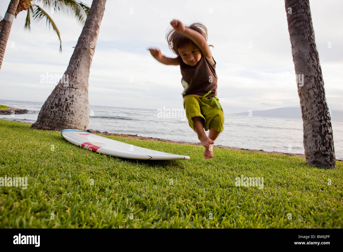 Garçon sautant hors de surf Banque D'Images