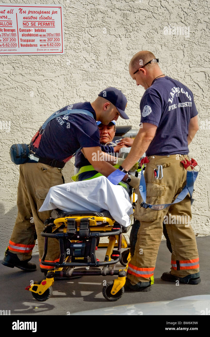 Les ambulanciers place un homme blessé sur une civière derrière un store sur 'la bande' à Las Vegas, Nevada. Banque D'Images