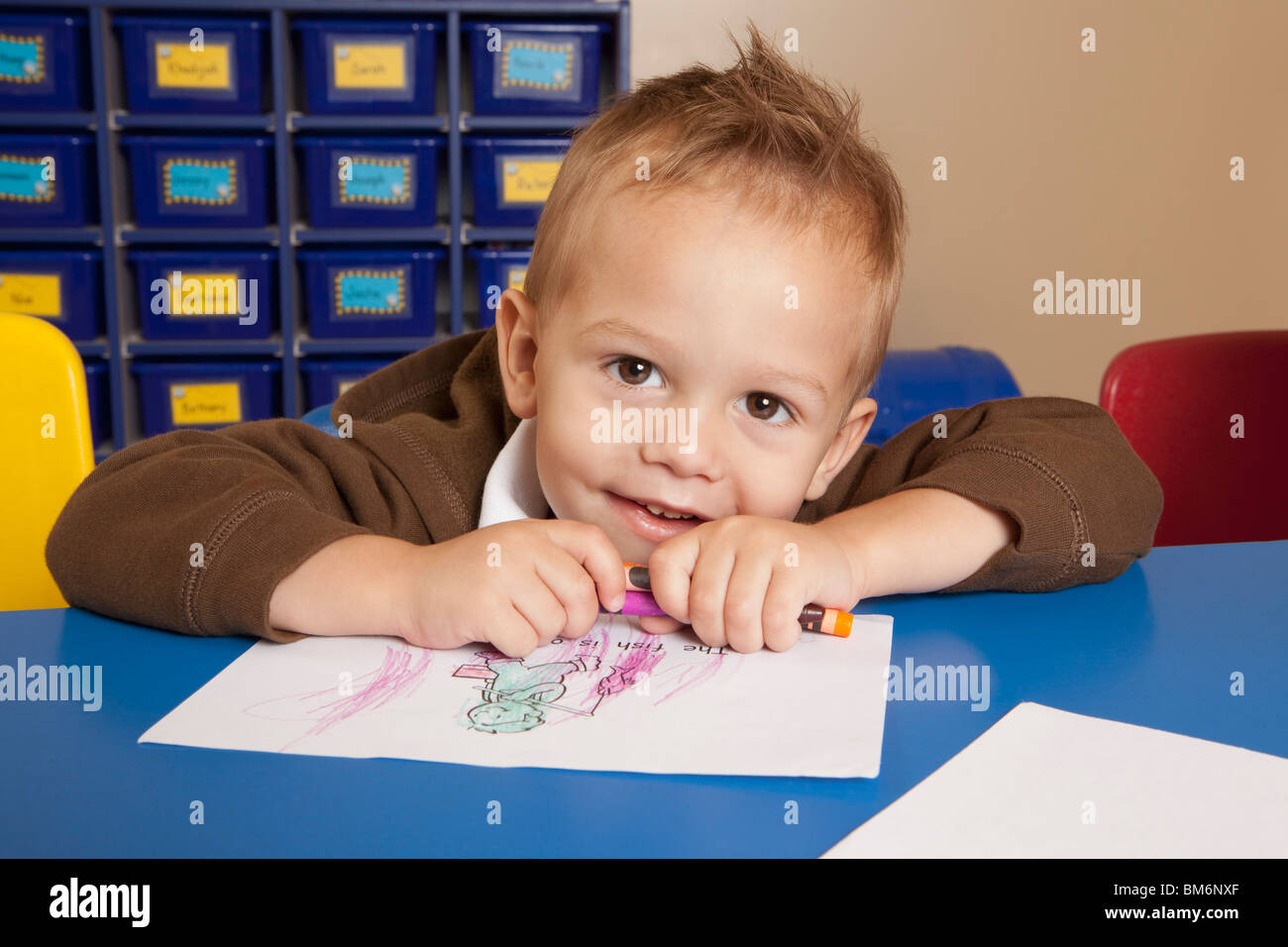 Fort Lauderdale, Floride, États-Unis d'Amérique ; un jeune garçon à colorier une table dans une salle de classe Banque D'Images