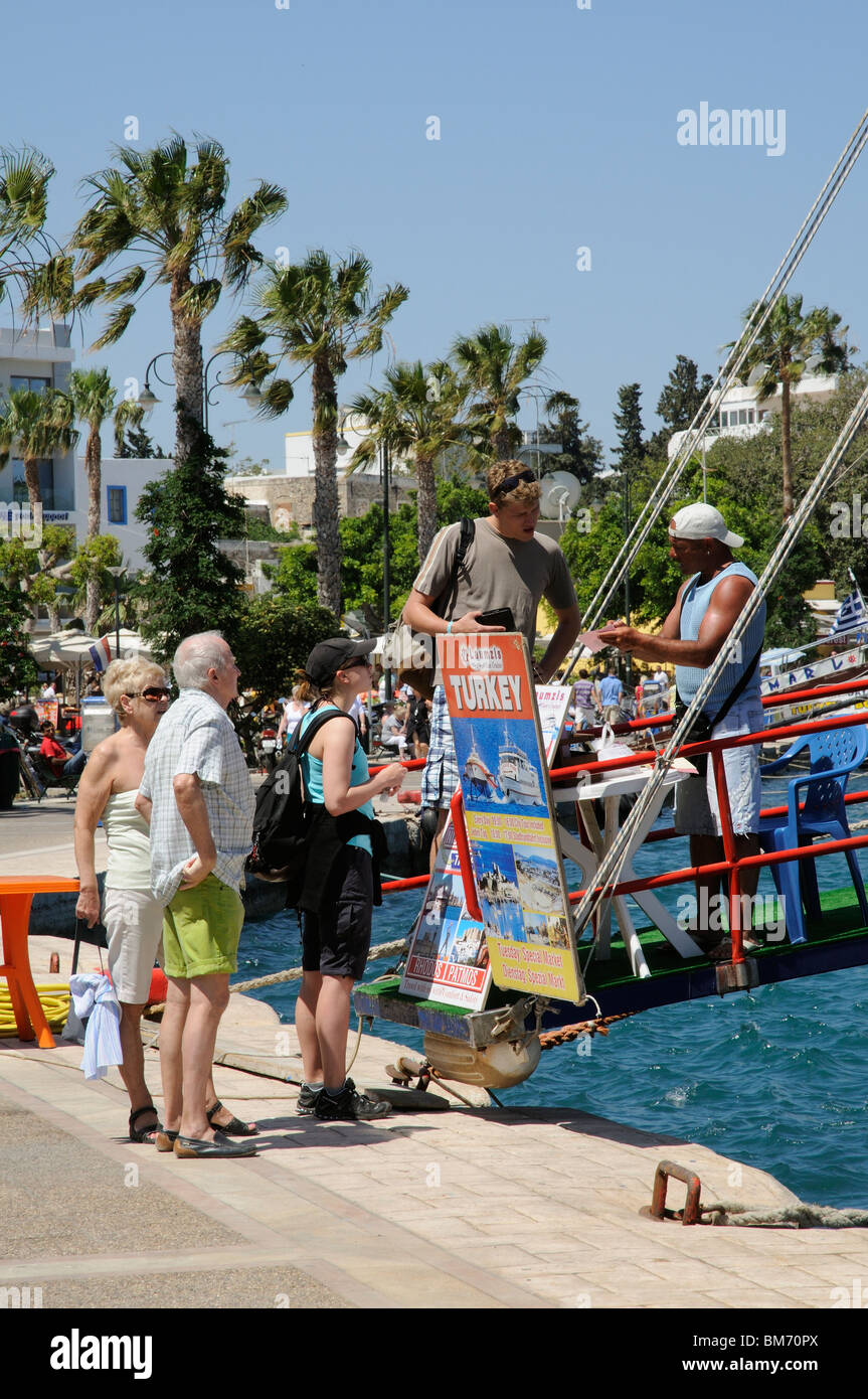 Les vacanciers sur le quai à Kos, Grèce Réservez un voyage en bateau à Bodrum Turquie Banque D'Images