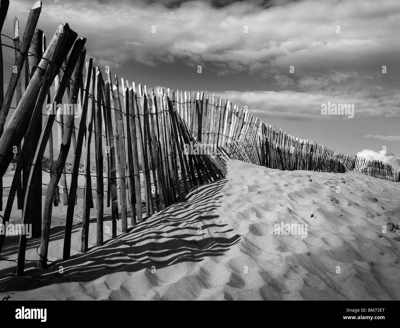 Dunes de sable de Formby Point près de Liverpool sur la côte de Merseyside, clôture, montrant des traces de pas dans le sable en noir et blanc Banque D'Images