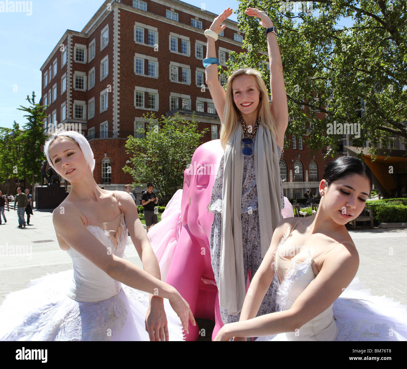 Deux ballerines et directeur de l'organisme de bienfaisance de la famille éléphant, Ruth Powys, poser à côté d'un des éléphants placés à Londres. Banque D'Images