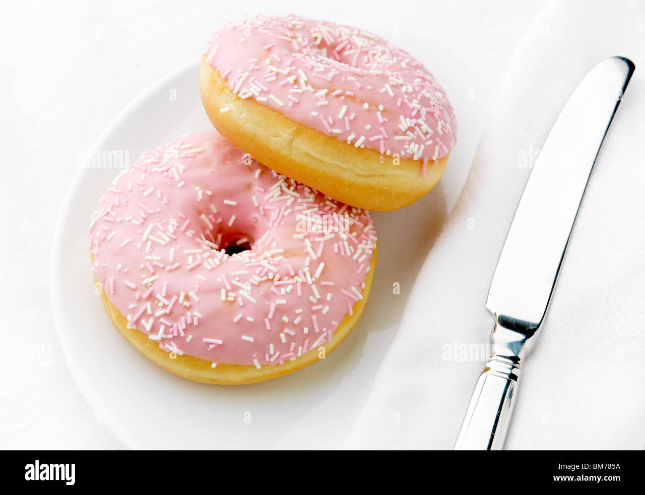 Donut rose avec couteau, high key Banque D'Images