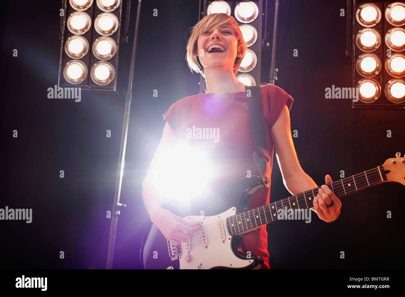 Une femme jouant de la guitare électrique sur scène Banque D'Images