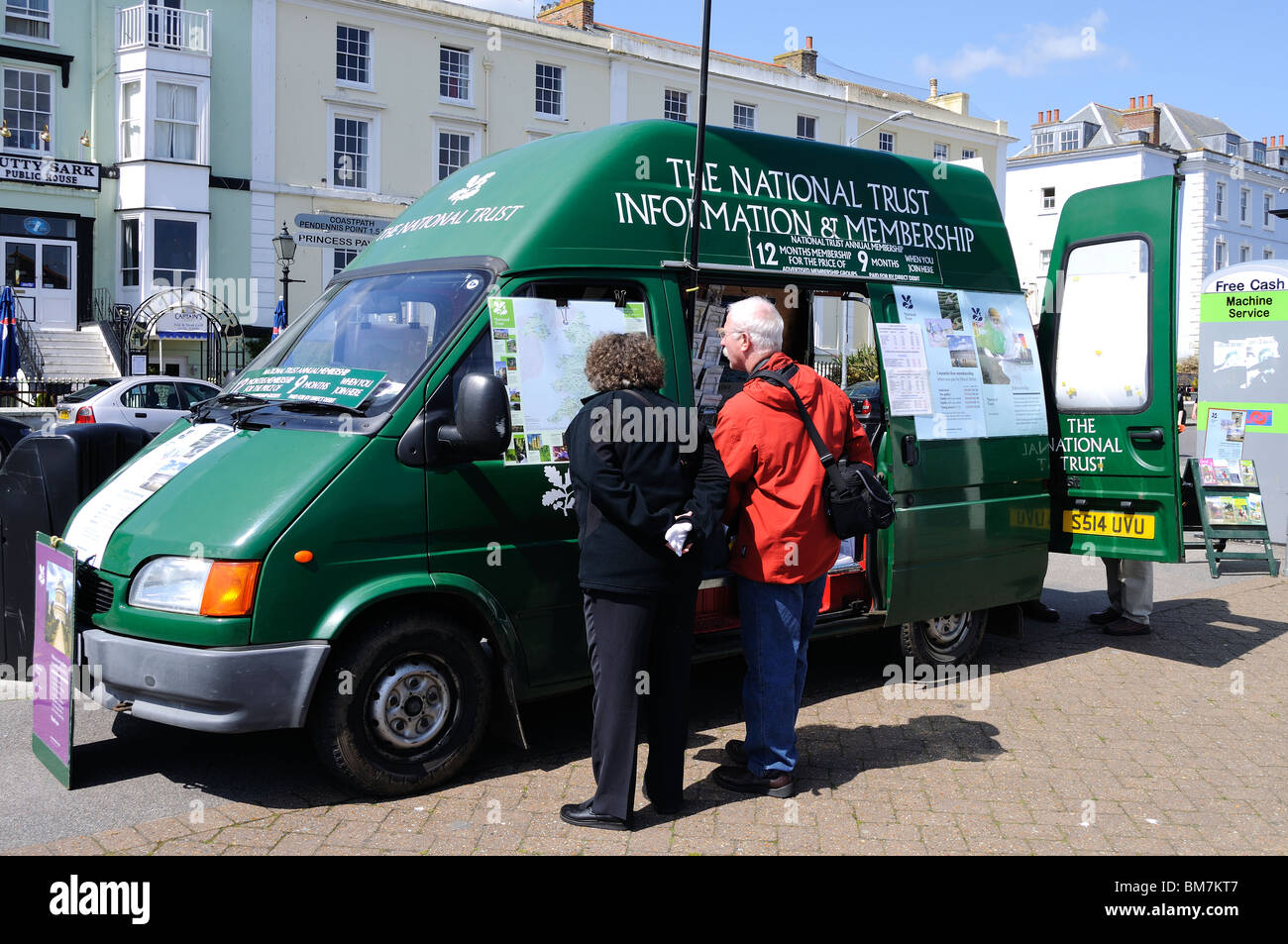 Un homme et une femme à se joindre à l'information sur une fiducie nationale van vente à Falmouth, Cornwall, uk Banque D'Images