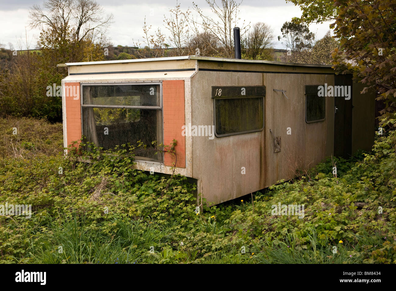 UK, Cornwall, Laneast, vieille caravane statique non utilisés dans la zone de végétation Banque D'Images